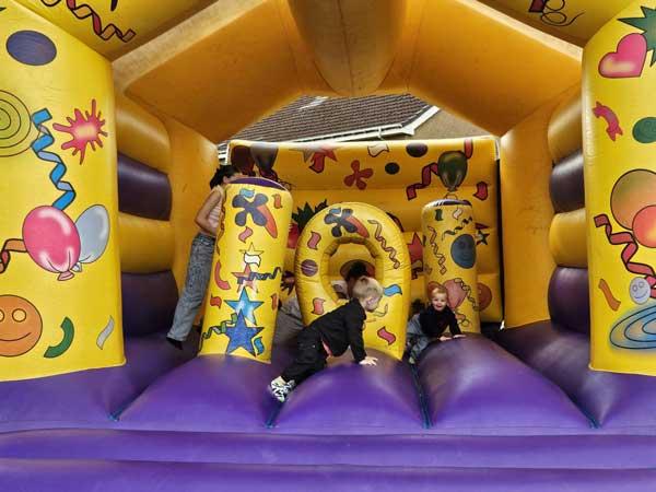 Children Playing On Bouncy Castle At Fun Day