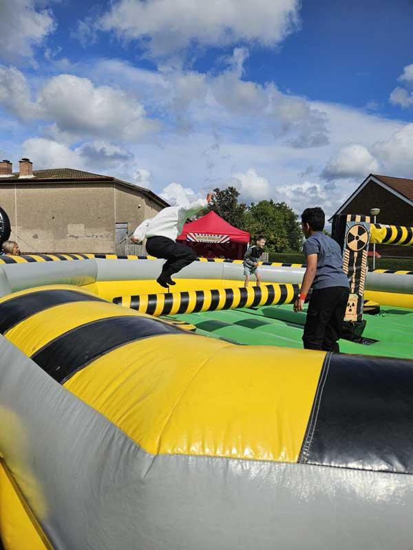 Children Playing On Bouncy Castle At Fun Day